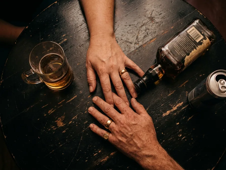 Mãos sobre a mesa de bar com grandes alianças